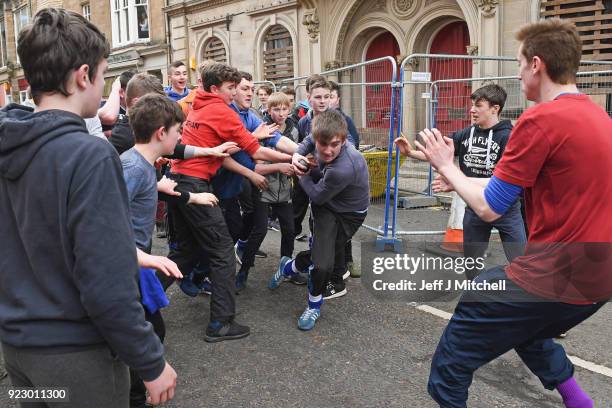 Youths chase after the leather ball during the annual 'Fastern Eve Handba' event in Jedburgh's High Street in the Scottish Borders on February 22,...