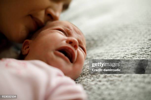 mother calming her crying baby girl - mom shouting stock pictures, royalty-free photos & images