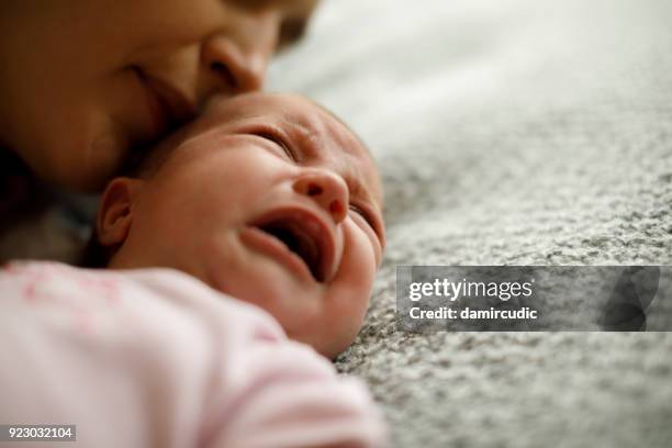 mãe, acalmando a menina bebê chorando - cólica - fotografias e filmes do acervo