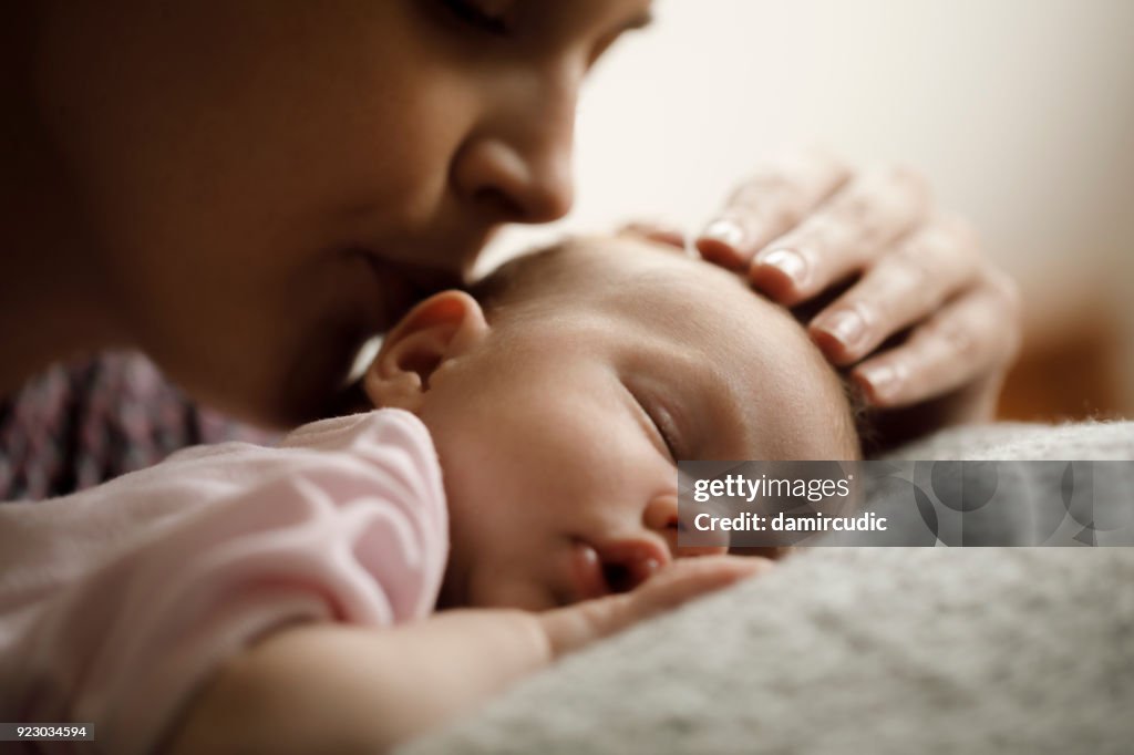 Mother kissing her sleeping baby