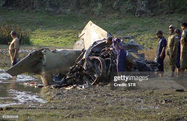 An Indian Air Force officer inspects a crashed MiG-27 fighter jet in a tea garden near New Jalpaiguri, in the state of West Bengal on October 23,...