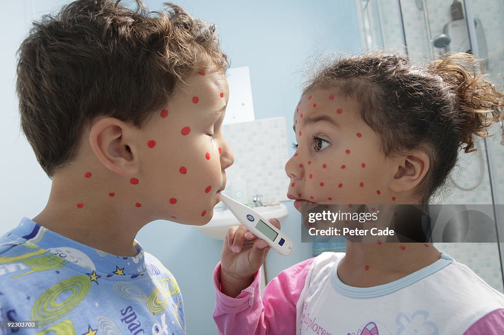 Children with spots and thermometer