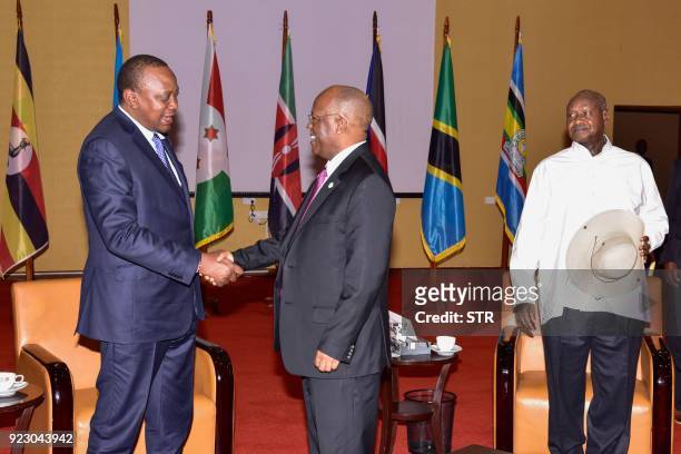 Kenyan President Uhuru Kenyatta shakes hands with Tanzanian President John Magufuli as Ugandan President Yoweri Museveni looks on during the 19th...
