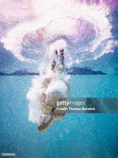 young female jumping into pool doing cannon ball - do it stock pictures, royalty-free photos & images