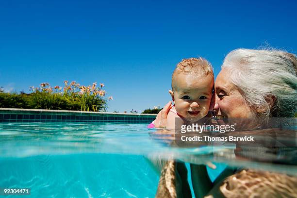 grandmother with baby granddaughter in pool - disruptagingcollection 個照片及圖片檔