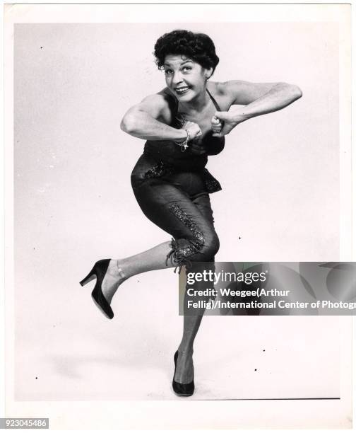 View of American comedienne and actress Martha Raye as she dances the Charleston against a white background, twentieth century.