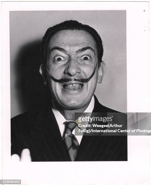 Portrait of the Spanish surrealist painter and sculptor Salvador Dali as he makes a comic face, New York, New York, 1940s or 1950s.