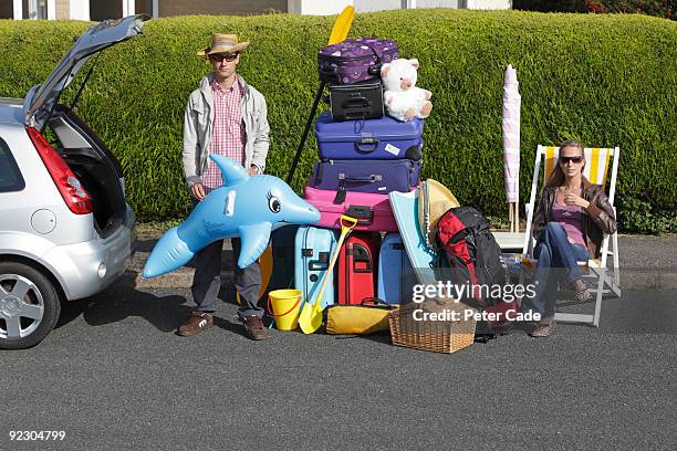 couple loading car for holiday - high up stockfoto's en -beelden