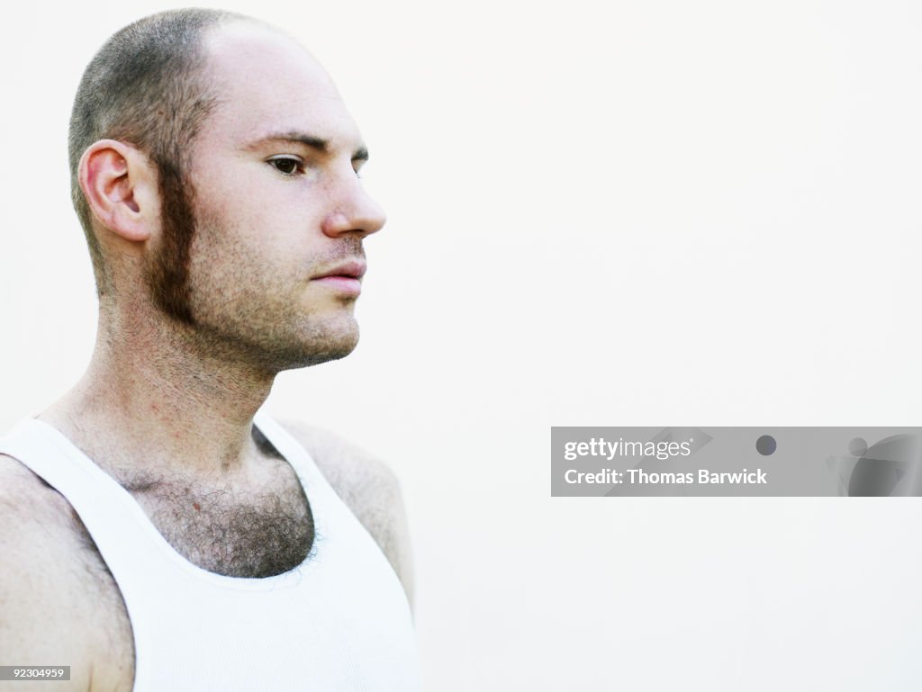 Young male standing against white background  