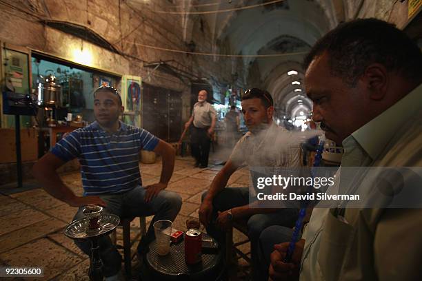 Palestinian man smokes a nargilla water pipe as he sits with frinds at a coffee shop in the vaulted Mamluke-era Cotton Market of the Old City on...