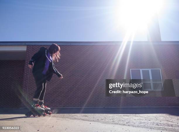 teenage girl rollerblading by a brick building. - harpazo hope stock pictures, royalty-free photos & images