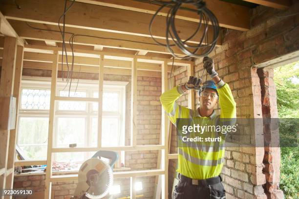 young electrician on site - black glove stock pictures, royalty-free photos & images