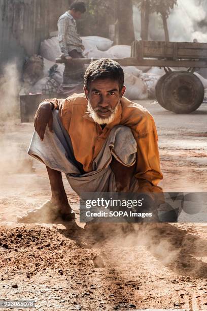 Road worker, brushes the sandy ground to even the surface of the road. The manual labour involved in resurfacing the roads is extraordinary. They...