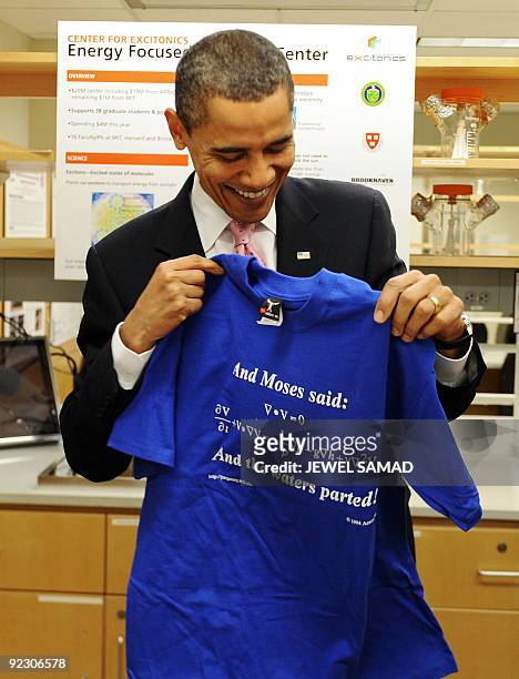 President Barack Obama holds a T-shirt given to him as he toured a research laboratory at the Massachusetts Institute of Technology , an institution...