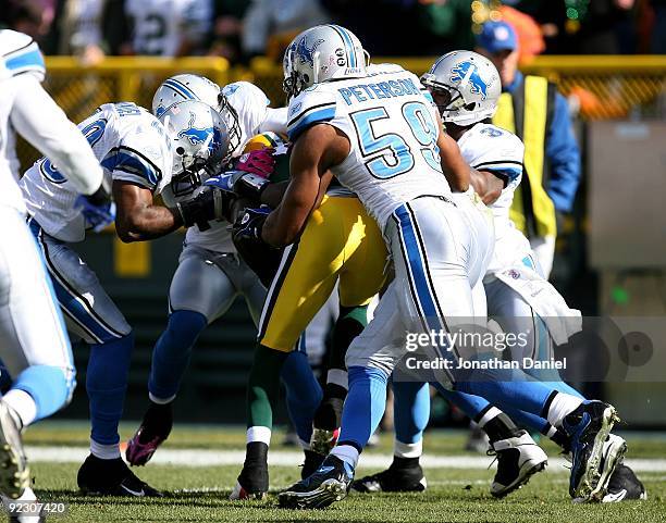 Donald Driver of the Green Bay Packers is gang-tackled by members of the Detroit Lion defense including Julian Peterson after breaking a Packer...