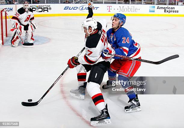 Paul Martin of the New Jersey Devils skates with the puck under pressure by Ryan Callahan of the New York Rangers on October 22, 2009 at Madison...