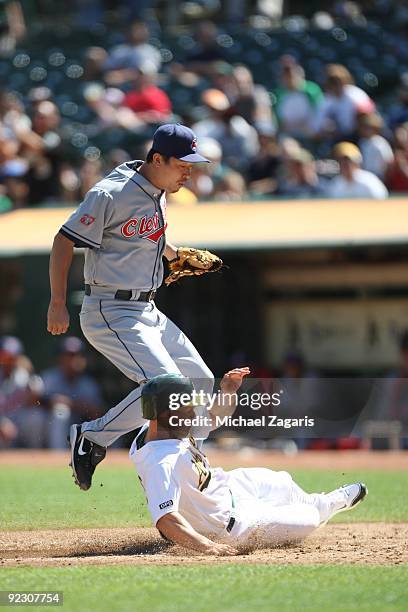 Mark Ellis of the Oakland Athletics scores after a wild pitch from Tomo Ohka of the Cleveland Indians during the game against the Indians at the...