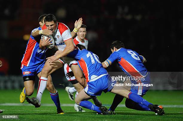 Kevin Sinfield of England is tackled by Olivier Elima, Remi Casty and David Ferriol of France during the Gillette Four Nations match between England...