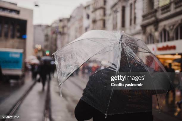 イスタンブールの人々 が、トルコのイスタンブールのタクシム広場の雨の日に歩いています。 - torrential rain ストックフォトと画像