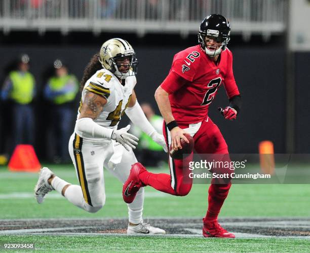 Matt Ryan of the Atlanta Falcons scrambles away from Hau'oli Kikaha of the New Orleans Saints at Mercedes-Benz Stadium on December 7, 2017 in...