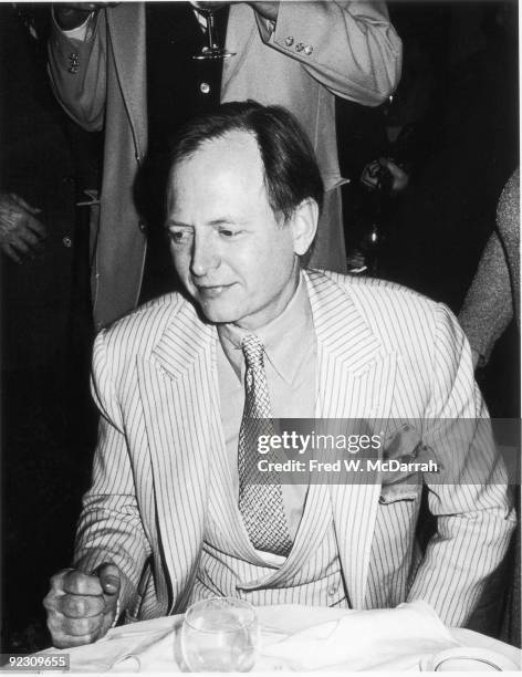 American author and journalist Tom Wolfe sits at a table at an unidentified event, January 27, 1980.