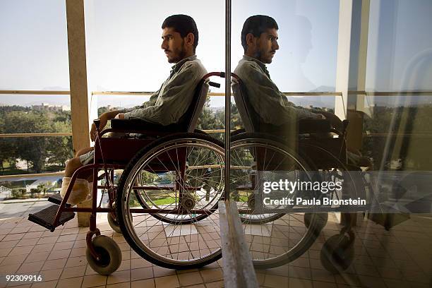 Soldier Achin Gul a double amputee is reflected in the glass door sitting in his wheelchairat the ANA Military hospital October 20, 2009 Kabul,...