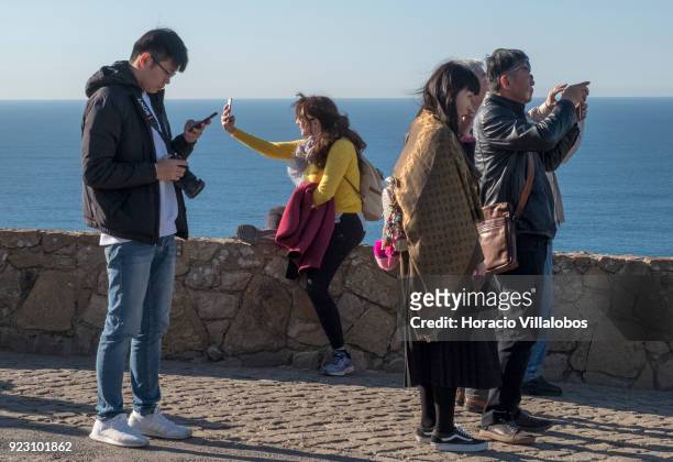 Tourists are seen taking selfies on a sunny winter afternoon in Cabo da Roca on February 22, 2018 in Sintra, Portugal. Cabo da Roca is a cape which...