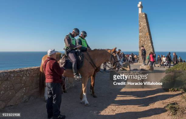 Horsemen of the National Republican Guard and tourists are seen on a sunny winter afternoon in Cabo da Roca on February 22, 2018 in Sintra, Portugal....