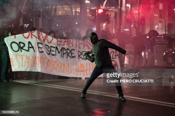 An Antifascist activist throws a bottle at police officers during a rally against an election campaign meeting organized by far-right movement...