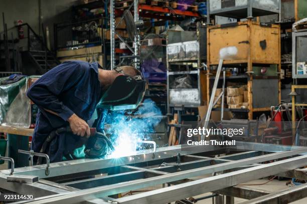 metal worker welding in factory - aluminio imagens e fotografias de stock