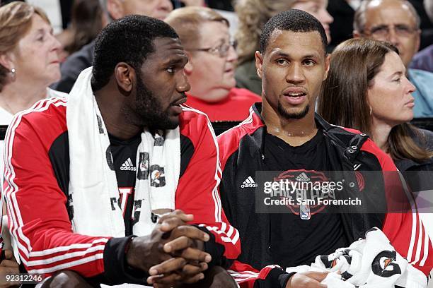 Greg Oden and Brandon Roy of the Portland Trail Blazers rest on the bench during a preseason game against the Denver Nuggets at The Rose Garden on...