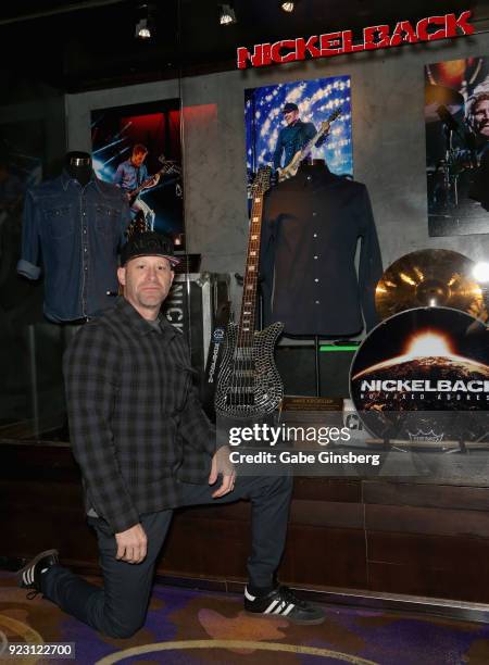 Bassist Mike Kroeger of Nickelback poses next to his bass and a shirt he wore on tour during a memorabilia case dedication ahead of the band's...
