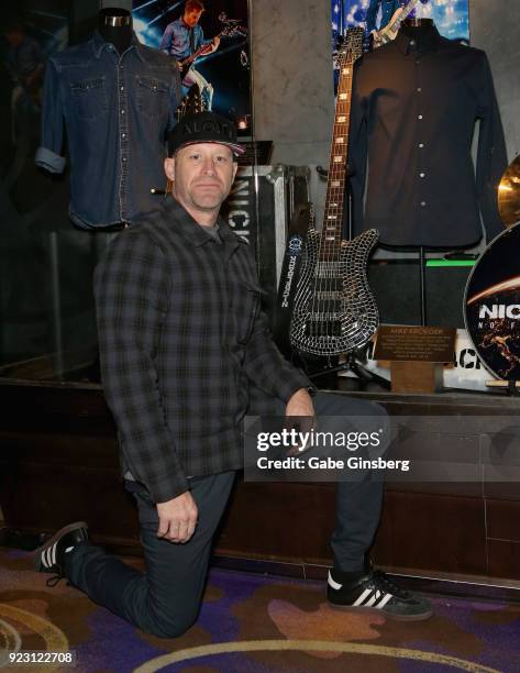 Bassist Mike Kroeger of Nickelback poses next to his bass and a shirt he wore on tour during a memorabilia case dedication ahead of the band's...