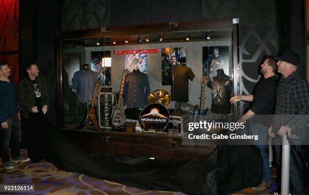 Drummer Daniel Adair, frontman Chad Kroeger, guitarist Ryan Peake and bassist Mike Kroeger of Nickelback unveil items belonging to the band during a...