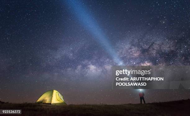 milky way and star galaxy on the sky with camping tent and people with flashlight - torcia elettrica foto e immagini stock