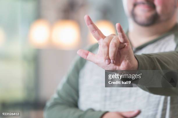 hombre diciendo i love you en lenguaje de señas - american sign language fotografías e imágenes de stock