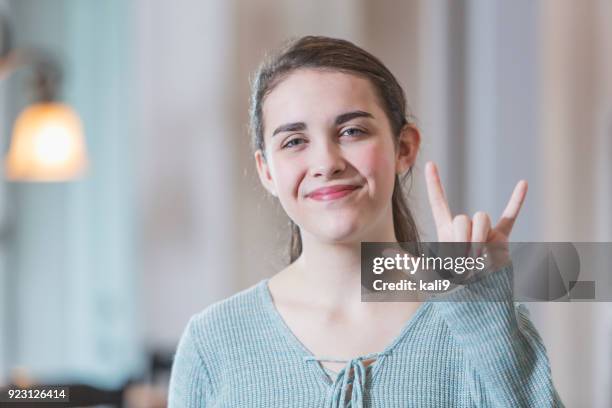 niña adolescente diciendo i love you en lenguaje de señas - american sign language fotografías e imágenes de stock