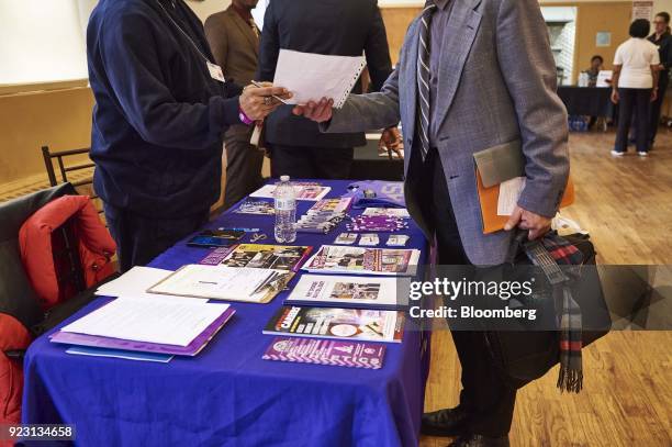 Representative, left, review the resume of a job seeker during a Shades of Commerce Career Fair in the Brooklyn borough of New York, U.S., on...