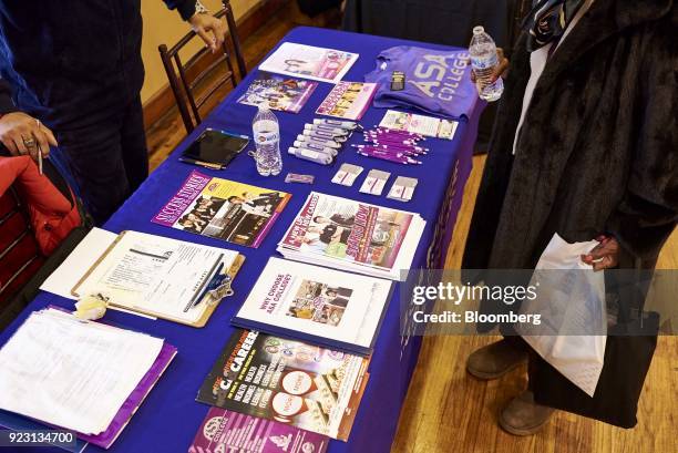 Job seeker reviews informational paperwork during a Shades of Commerce Career Fair in the Brooklyn borough of New York, U.S., on Saturday, Feb. 17,...