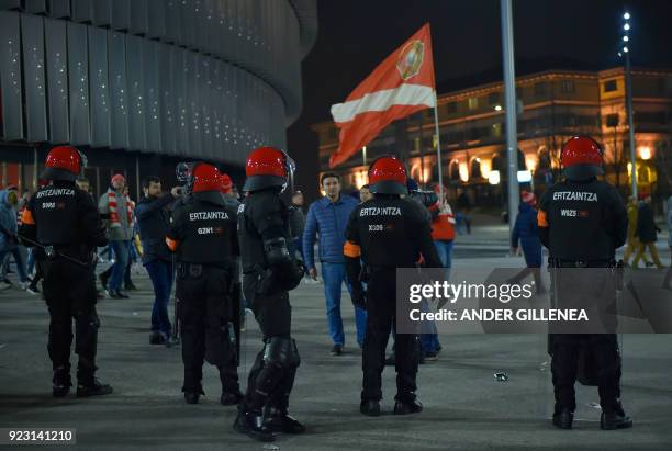 Spartak fans walk past Basque autonomous police officers outside the San Mames stadium after the Europa League Round of 32 second leg football match...