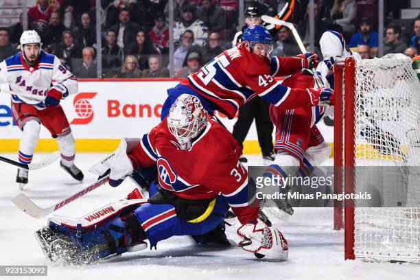 Goaltender Antti Niemi of the Montreal Canadiens reaches behind him to cover the puck as teammate Joe Morrow defends against Jimmy Vesey of the New...