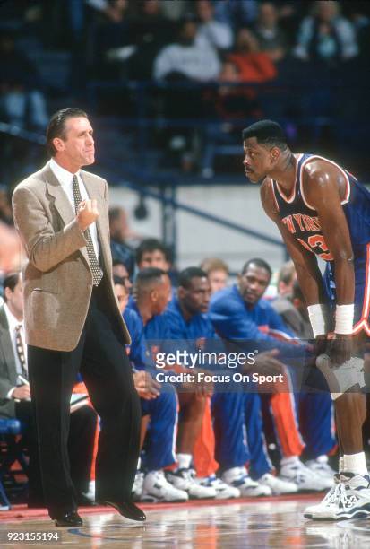 Head Coach Pat Riley of the New York Knicks talks with his player Patrick Ewing against the Washington Bullets during an NBA basketball game circa...