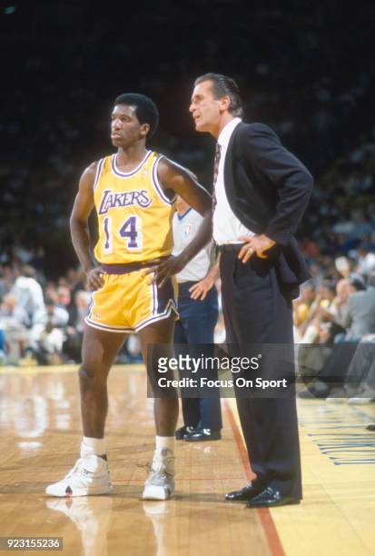 Head Coach Pat Riley of the Los Angeles Lakers talks with his player David Rivers during an NBA basketball game circa 1988 at The Forum in Inglewood,...