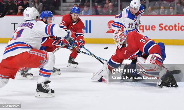 David Desharnais passes the puck to Jesper Fast of the New York Rangers in front of goaltender Antti Niemi of the Montreal Canadiens in the NHL game...