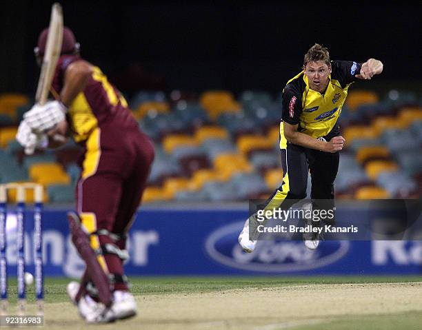Ashley Noffke of the Warriors bowls to Lee Carseldine of the Bulls during the Ford Ranger Cup match between the Queensland Bulls and the Western...