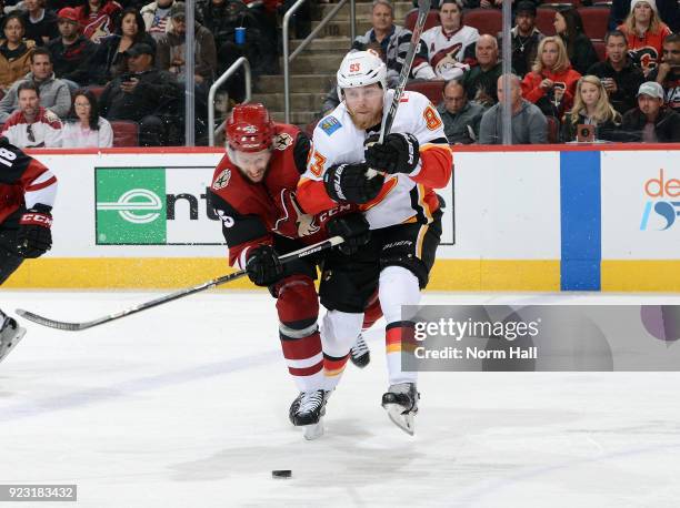 Sam Bennett of the Calgary Flames and Jason Demers of the Arizona Coyotes battle for a loose puck during the second period at Gila River Arena on...