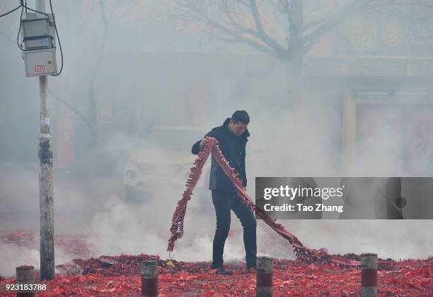 Merchant sets off firecrackers to pray for business booming in front of a wholesale market on February 23, 2018 in Harbin, Heilongjiang province of...