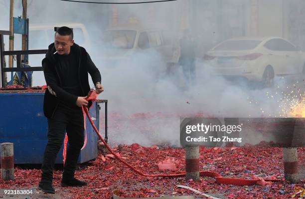 Merchant sets off firecrackers to pray for business booming in front of a wholesale market on February 23, 2018 in Harbin, Heilongjiang province of...