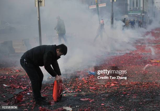 Merchant sets off firecrackers to pray for business booming in front of a wholesale market on February 23, 2018 in Harbin, Heilongjiang province of...