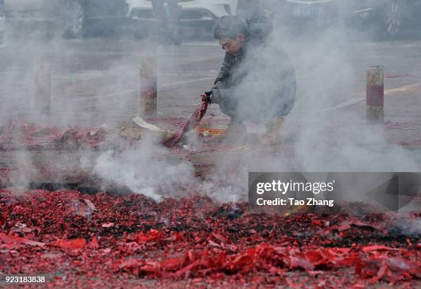 Merchant sets off firecrackers to pray for business booming in front of a wholesale market on February 23, 2018 in Harbin, Heilongjiang province of...